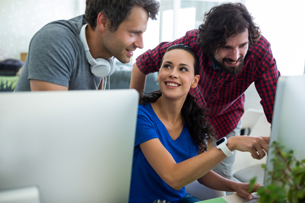 Group of friendly adult industry professionals looking at screen